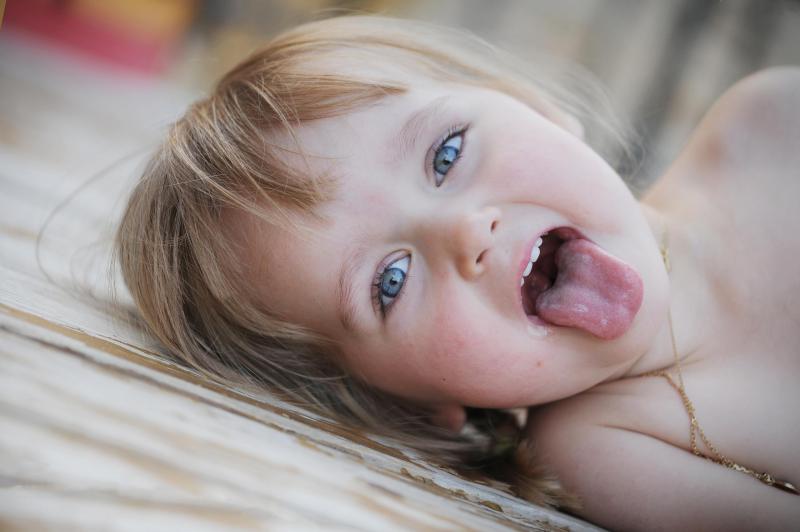 photographe naissance montpellier, photographe bébé montpellier, photo enfant montpellier, photographe enfant montpellier, shooting enfants montpellier,séance enfants montpellier, studio enfant montpellier, une petite blonde aux yeux bleus tire la langue au photographe, photographe palavad